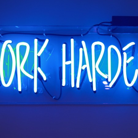Neon sign showing the words 'work harder'